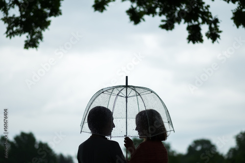 Two women walking park in rain and talk. Friendship and people communication. Rainy