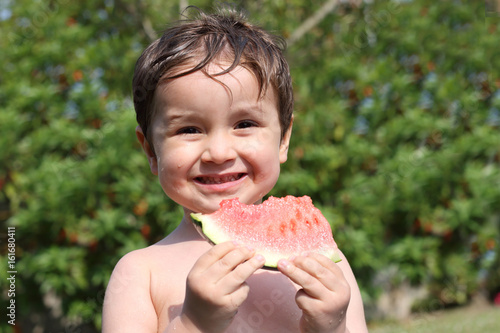 niño comiendo sandía en el jardín