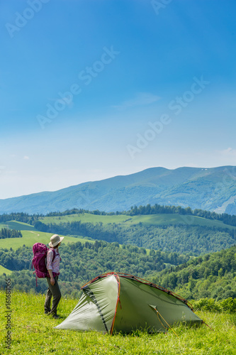  A woman with backpack and tent.