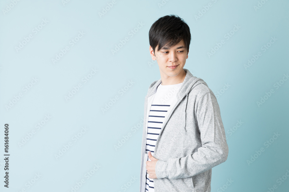 portrait of young asian man isolated on blue background portrait of young asian man isolated on blue background