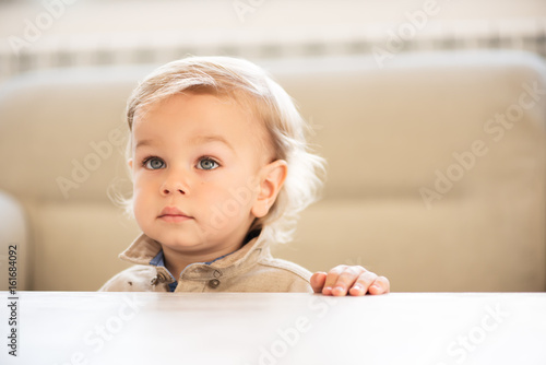 Portrait of little boy with blue eyes looking up.