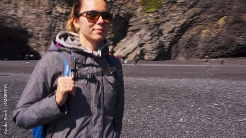 Woman exploring beautiful Reynisfjara beach near Vik, Icealnd photo