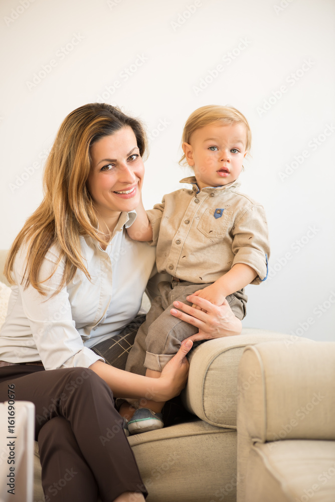 Beautiful mother and little baby boy sitting on the sofa. Family values. Beautiful mother and little baby boy sitting on the sofa. Family values.