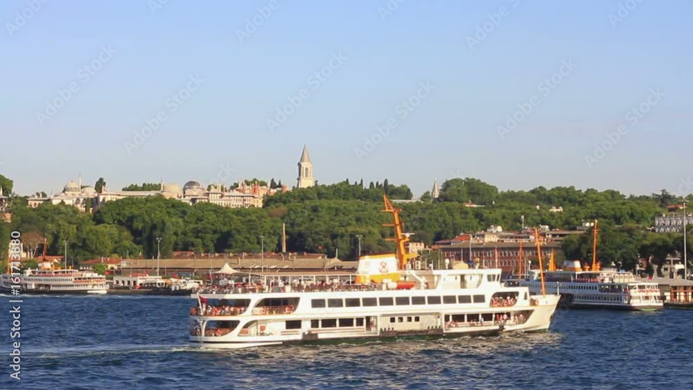 Historical Topkapi Palace and a ferry sailing into Goldenhorn. Topkapi Palace, Sarayburnu shore from the waterside in Istanbul, Turkey. Historical Topkapi Palace and a ferry sailing into Goldenhorn. Topkapi Palace, Sarayburnu shore from the waterside in Istanbul, Turkey.