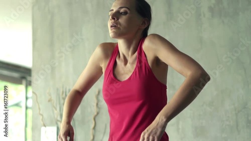 Young woman exercising arms during warm-up at home 
