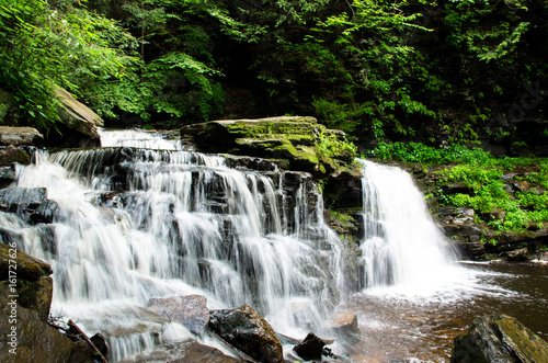 Fototapeta Naklejka Na Ścianę i Meble -  beautiful flowing waterfall over rocks in the forest