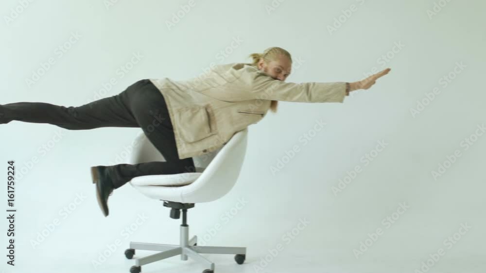 Slowmotion of Bearded funny businessman have fun riding on office chair ...