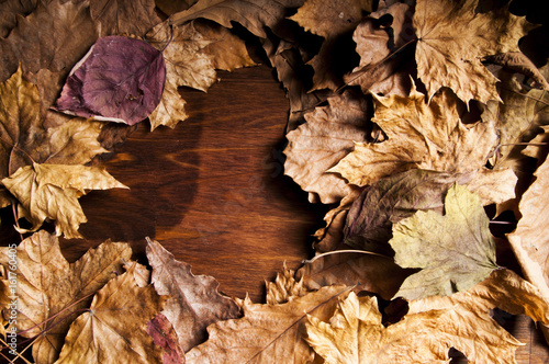 Autumn background with dry leaves on a wooden table