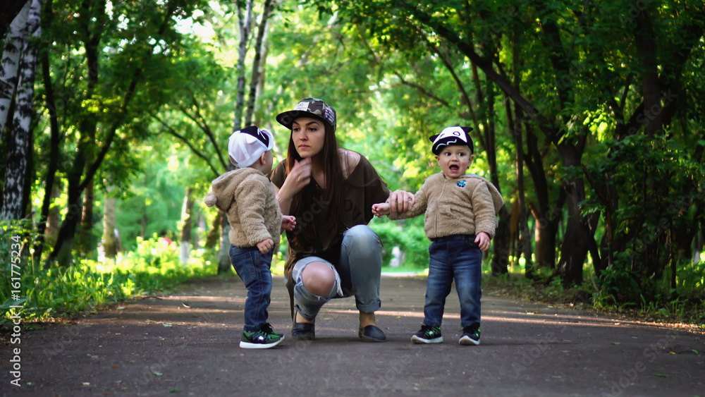 Young mother angry at the disobedience of children (twins) in the park