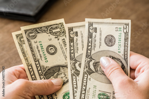 Woman's hands counting an american dollars.