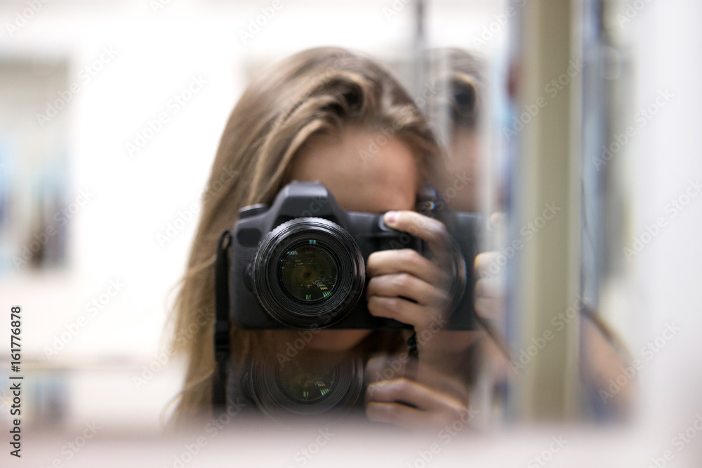A girl with a camera in a mirror image