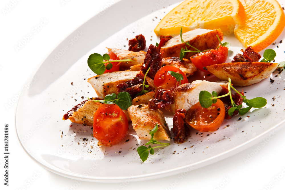 Grilled chicken fillet with vegetables salad on white background Grilled chicken fillet with vegetables salad on white background