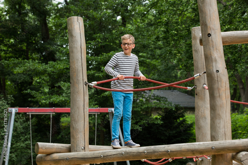 Heranwachsender / Kind auf Klettergerüst und spielt Heranwachsender / Kind auf Klettergerüst und spielt