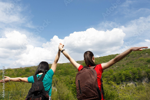 Young hiker girls with backpack enjoying and looking to the sky with clouds