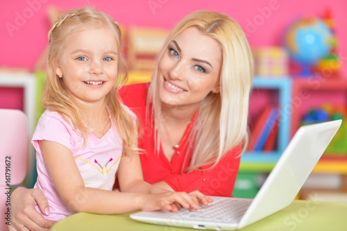 woman and little girl using   laptop