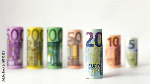 Gerollter 20 Euro Schein mit anderen Geldscheinen im Hintergrund