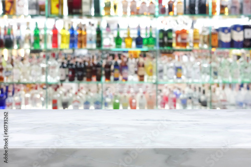 White stone bar top on blur colorful alcohol drink bottle background