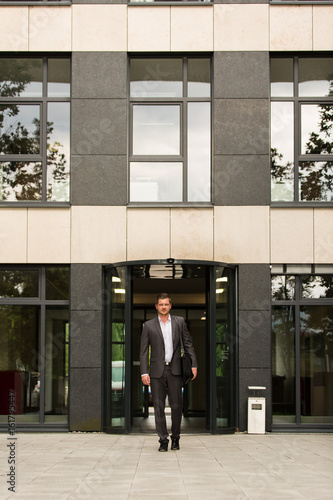 Business Mann / Herr verlässt Arbeitsgebäude / Feierabend / Termin © Timo Blaschke
