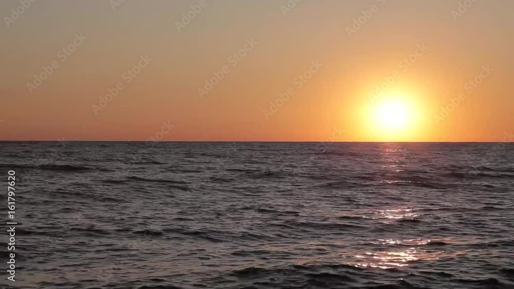 Beautiful sunset on the beach, amazing colors, a ray of light, sparkling through the clouds above the sea Beautiful sunset on the beach, amazing colors, a ray of light, sparkling through the clouds above the sea