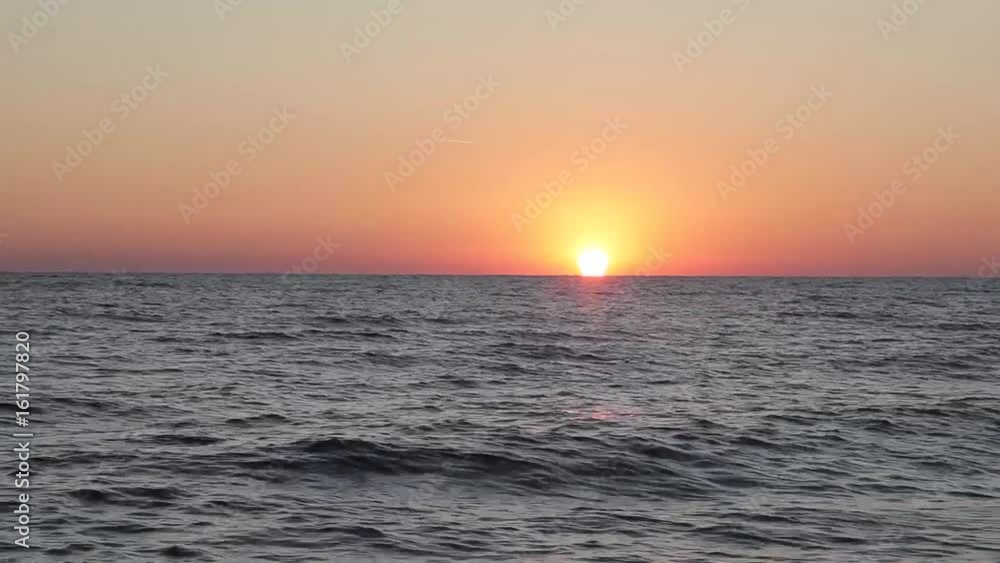 Beautiful sunset on the beach, amazing colors, a ray of light, sparkling through the clouds above the sea Beautiful sunset on the beach, amazing colors, a ray of light, sparkling through the clouds above the sea