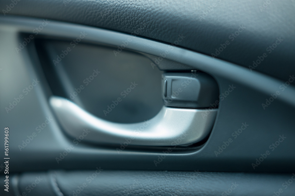 close up. car leather interior detail of door handle and lock upside it. image for car,interior,transport and abstract concept
