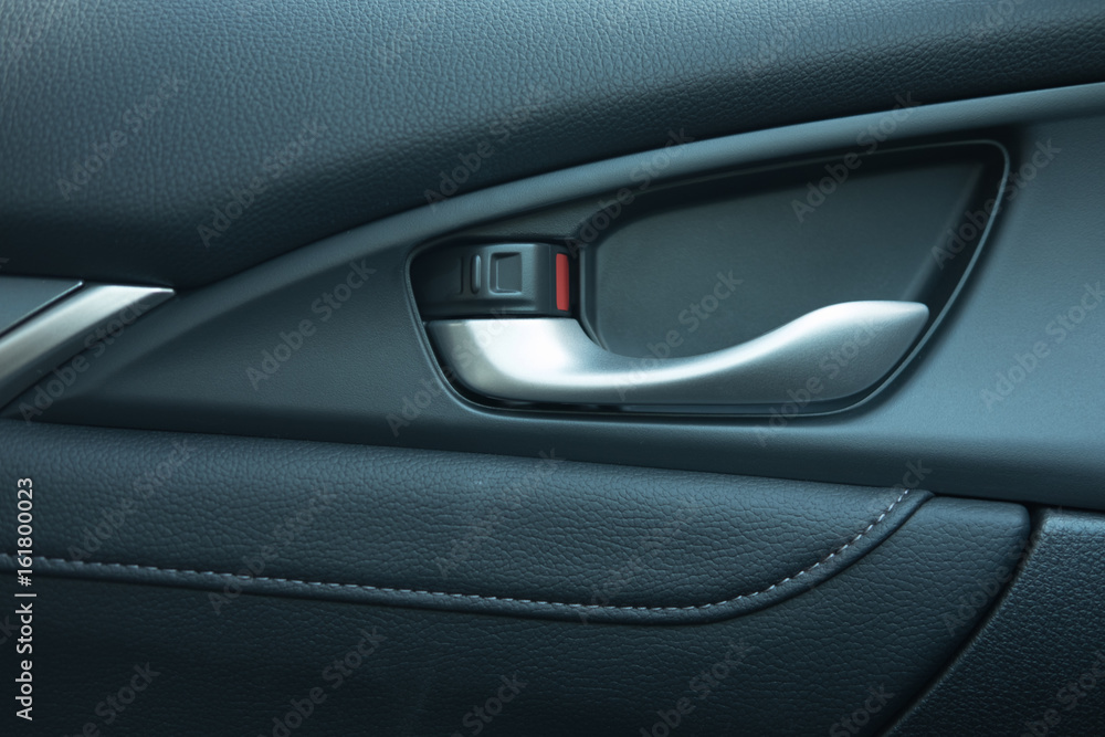 close up. car leather interior detail of door handle and lock upside it. 
