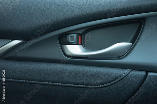 close up. car leather interior detail of door handle and lock upside it.  © Pangzz