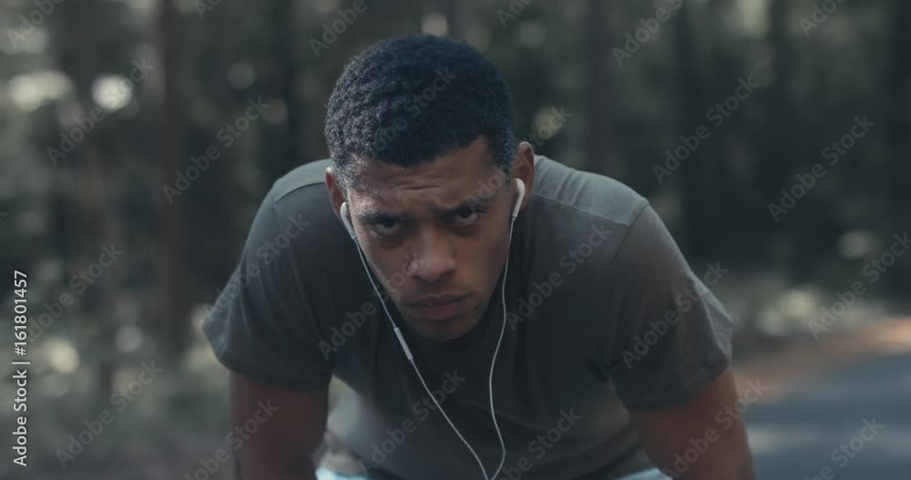 Young fit African American catching breath after jogging on the forest road, turning and smiling into camera. 4K UHD Young fit African American catching breath after jogging on the forest road, turning and smiling into camera. 4K UHD