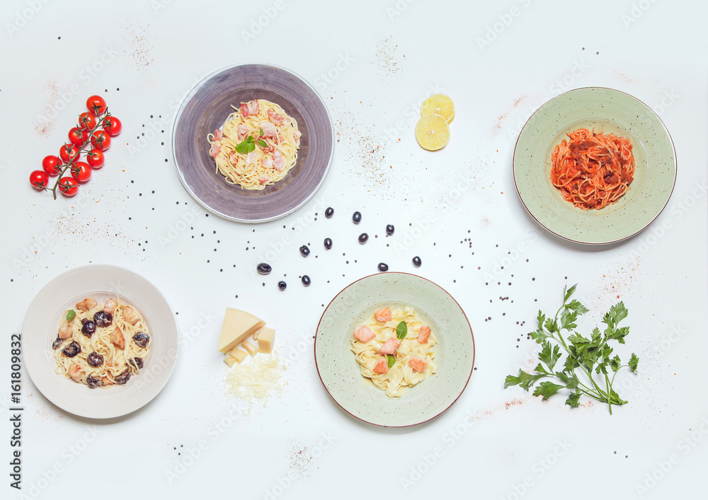 Plates with different kinds of pasta on a white table. view from above. Plates with different kinds of pasta on a white table. view from above.