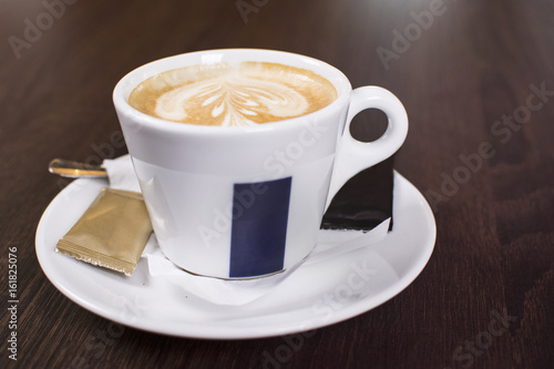 Cup of coffee with beautiful latte art. Tasty cup of coffee on wooden background with beautiful latte art.