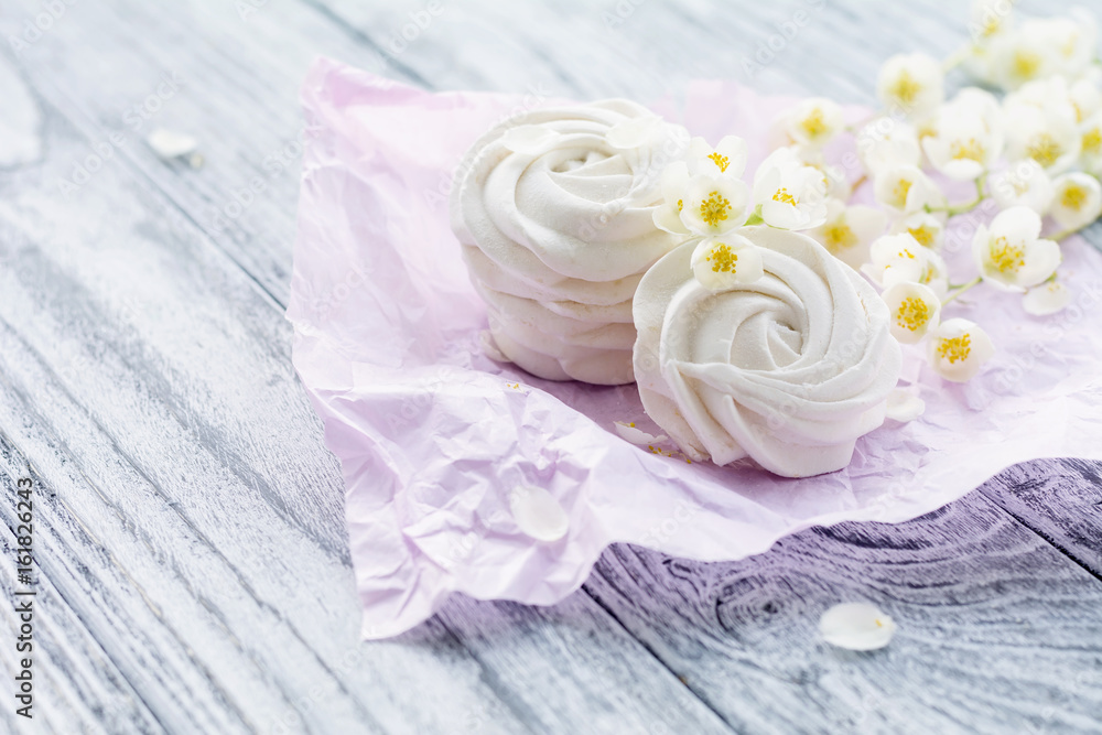 Homemade marshmallow and jasmine branch on grey wooden table Homemade marshmallow and jasmine branch on grey wooden table