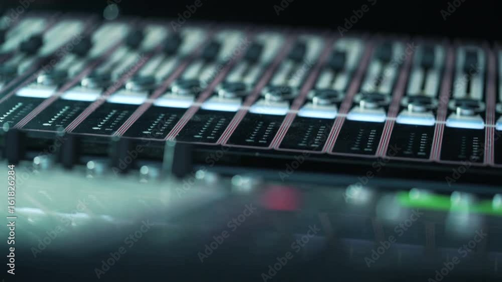 audio mixer in a studio, the automatic knobs moving up and down on