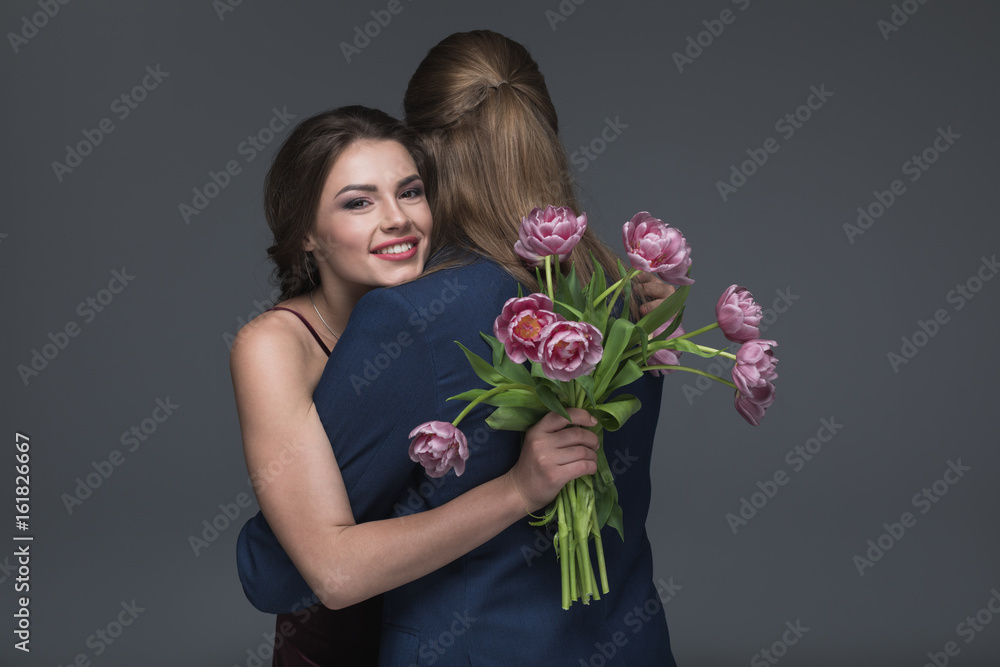happy young woman embracing his boyfriend with bouquet of peonies happy young woman embracing his boyfriend with bouquet of peonies