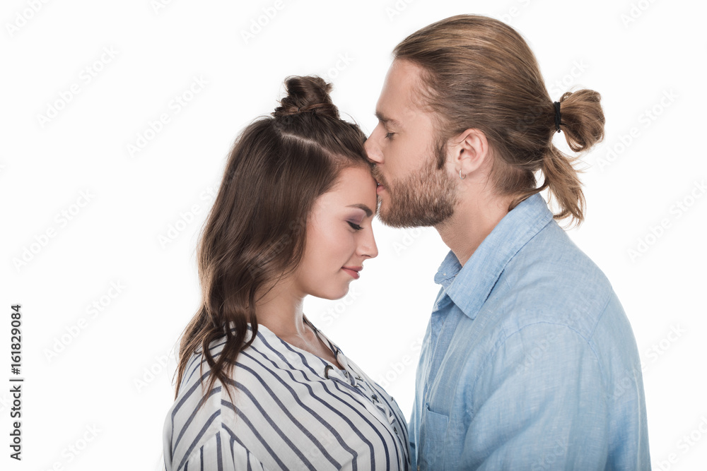Side view of handsome young man kissing beautiful girl with closed eyes Side view of handsome young man kissing beautiful girl with closed eyes