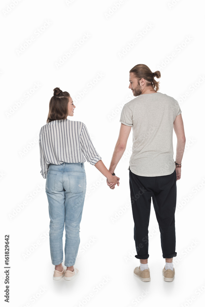 young caucasian couple holding hands and looking at each other, isolated on white young caucasian couple holding hands and looking at each other, isolated on white