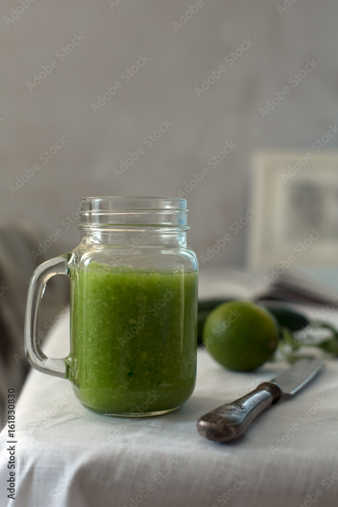 Fresh organic green smoothie with spinach, cucumber on a white tableware Fresh organic green smoothie with spinach, cucumber on a white tableware