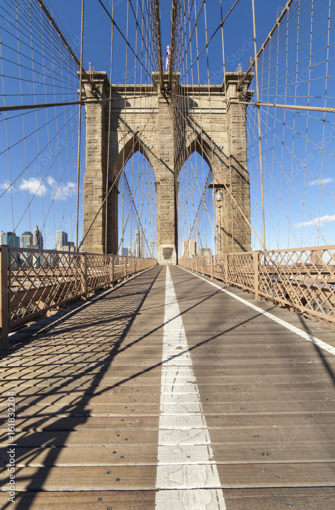 Fototapeta premium Brooklyn Bridge: widok na wieżę pośrodku ścieżki dla pieszych