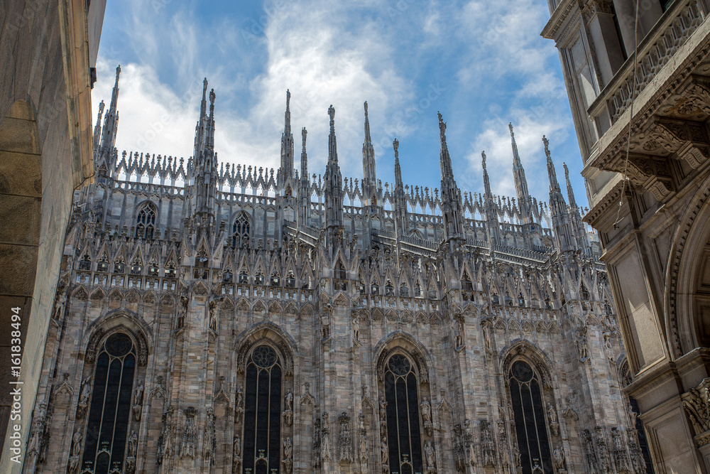 Outer side facade of the Milan cathedral (Duomo) with its characteristic pinnacles in  gothic style. Milan, Italy.;