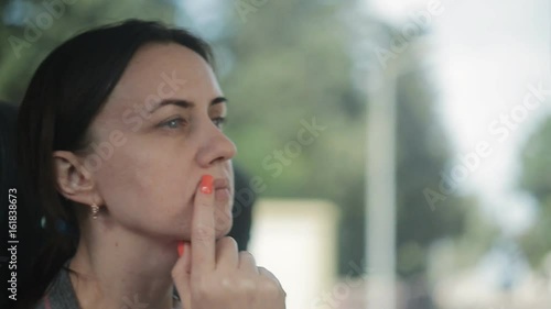 A woman is riding in a tourist bus sitting by the window photo