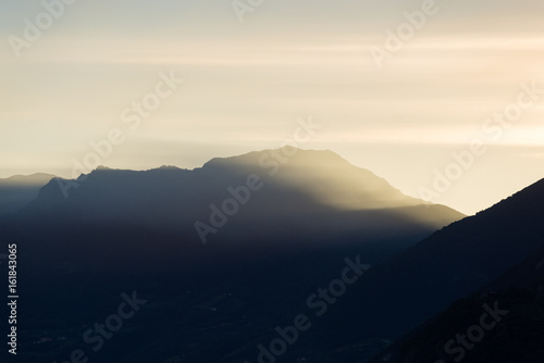 Beautiful foggy sunrise sunset silhouette reflection at Iseo lake in Italy in summer