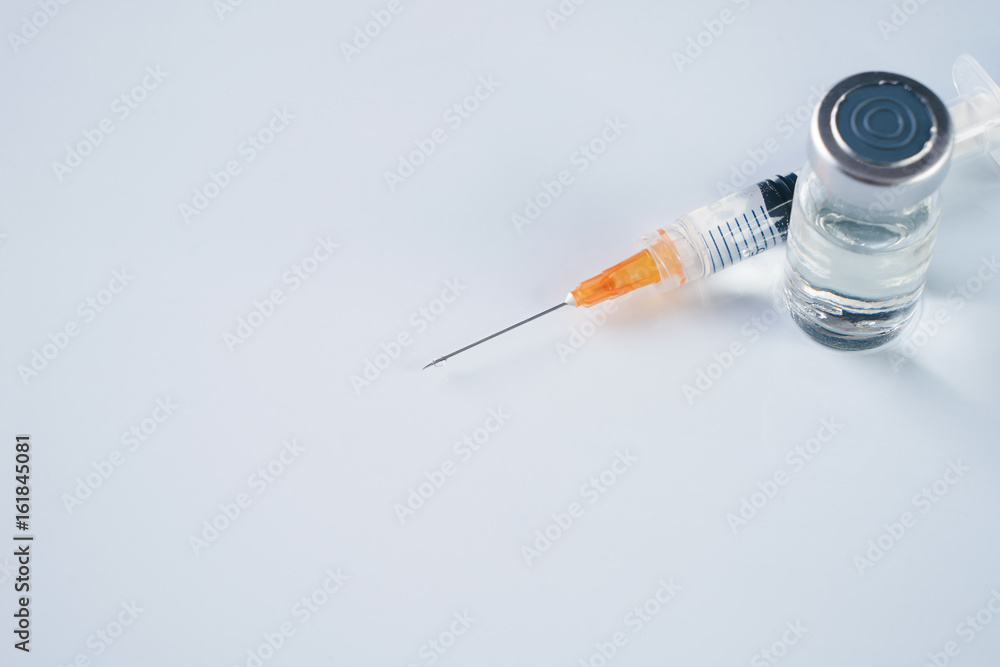 Medical ampoules, infusion and syringe with injection isolated on white background with copy space. Ampules with antibiotics closed with caps in a row. Syringe with needle lying on the vial with drug Medical ampoules, infusion and syringe with injection isolated on white background with copy space. Ampules with antibiotics closed with caps in a row. Syringe with needle lying on the vial with drug