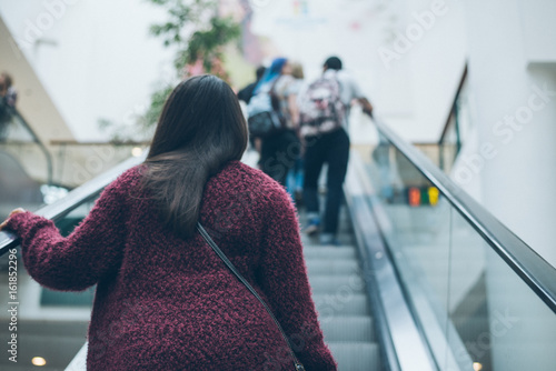 young woman on escalator in mall