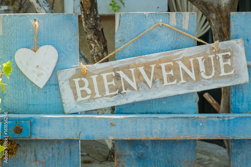 Plaque « Bienvenue », decoré avec un coeur blanc en bois.