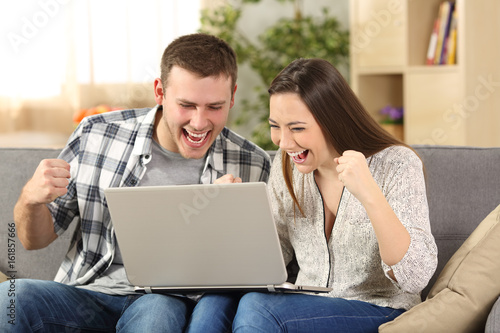 Excited couple reading news on line