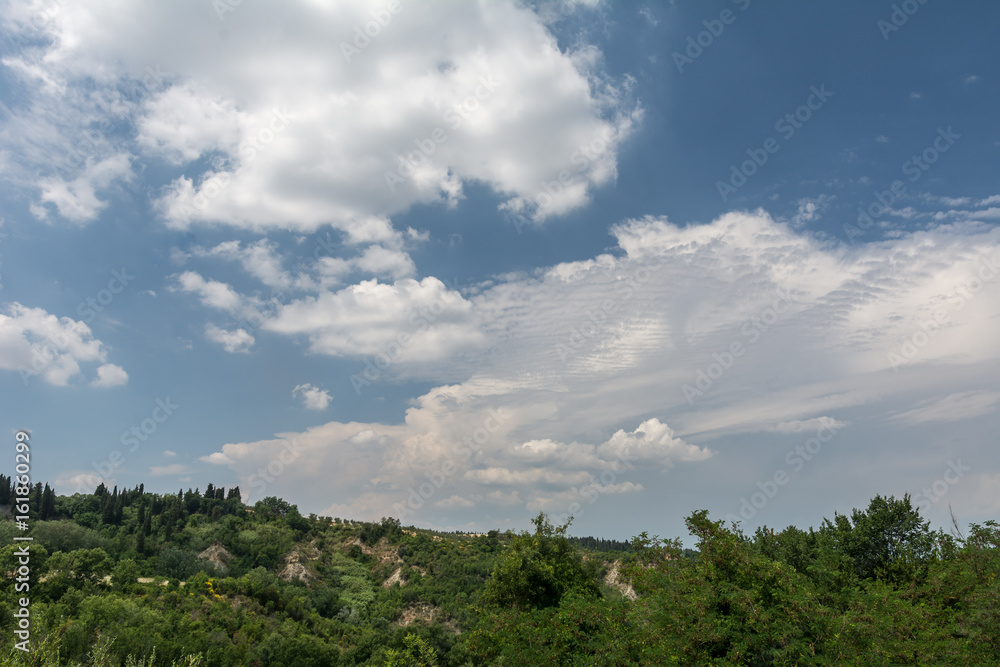 Landschaft in der Toskana mit Hügel und weissen Wolken Landschaft in der Toskana mit Hügel und weissen Wolken
