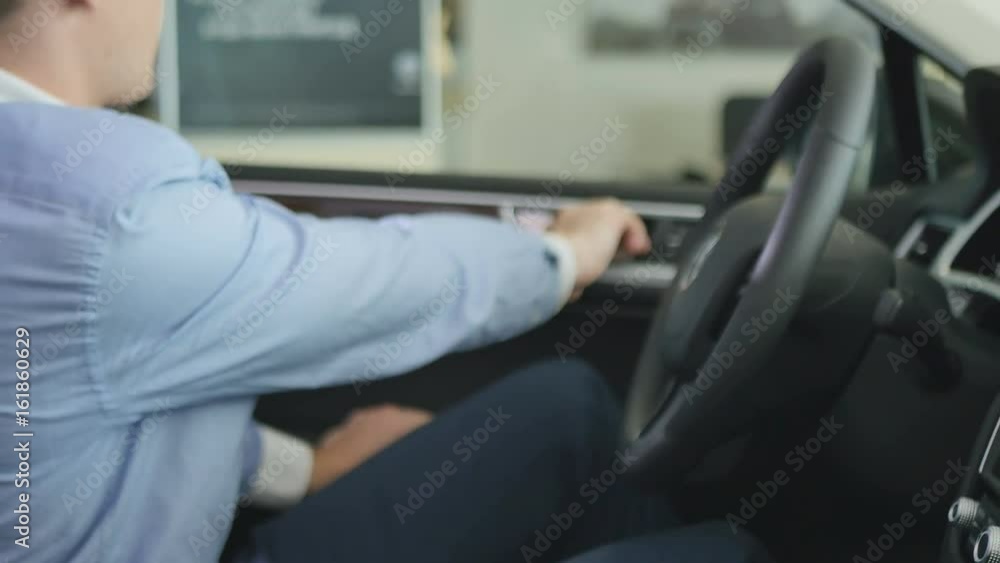 The man sit in car and hold hands by the wheel The man sit in car and hold hands by the wheel
