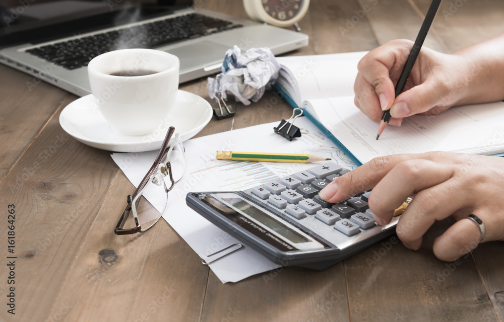 business woman using calculator with hot coffee and computer business woman using calculator with hot coffee and computer