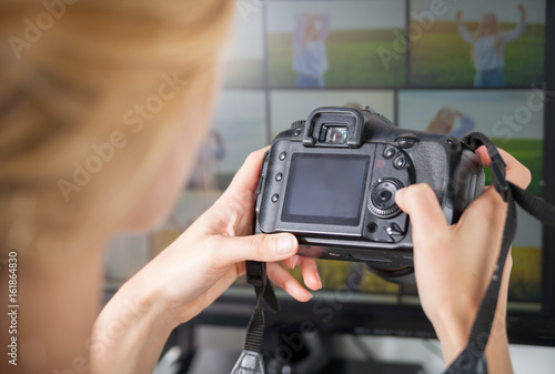 Freelance photographer woman at home office editing photos, blank camera screen