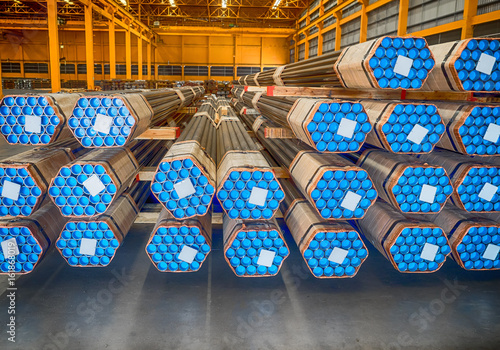 Photos Stack of steel pipes in industrial warehouse.