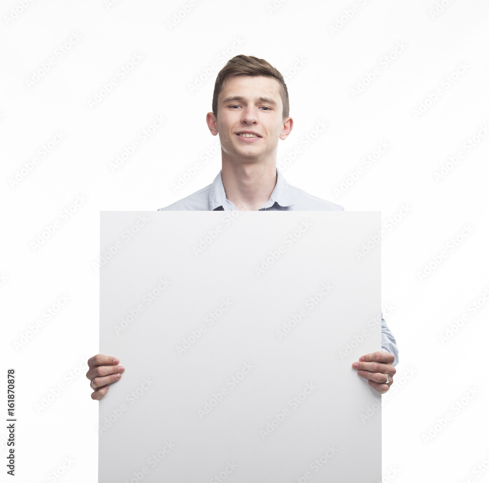 Young happy man portrait of a confident businessman showing presentation, pointing paper placard gray background. Ideal for banners, registration forms, presentation, landings, presenting concept. Young happy man portrait of a confident businessman showing presentation, pointing paper placard gray background. Ideal for banners, registration forms, presentation, landings, presenting concept.